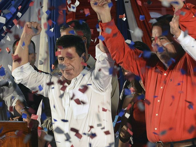 PPB204 - Asunción, -, PARAGUAY : Paraguayan presidential candidate for the Colorado Party, Horacio Cartes (L) and his Vice-President Juan Afara, wave after winning the elections in Asuncion on April 21, 2013. AFP PHOTO/Pablo PORCIUNCULA