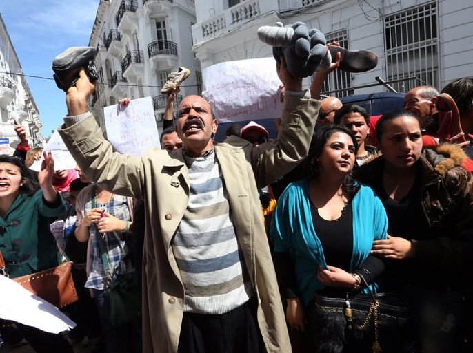 epa03644430 Tunisian protesters hold up their shoes and shout slogans during a demonstration against Tunisian Minister of Women’s Affairs Sihem Badi, in Tunis, Tunisia, 29 March 2013. According to reports, protesters demanded the resignation of Badi accusing her of supporting a kindergarten where a three-year-old girl was reportedly raped. EPA/MOHAMED MESSARA
