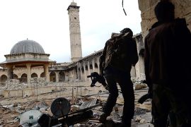 Syrian rebel fighters walk in the Umayyad Mosque complex in the old city of Aleppo on April 16, 2013. After nine months of fighting that has devastated many districts in Aleppo, rebels now control more than half of the city. AFP PHOTO / DIMITAR DILKOFF