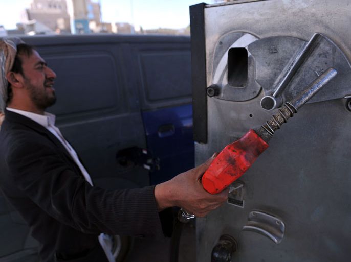 epa03501375 A pump attendant holds a fuel nozzle to fill a vehicle with fuel at a gasoline station in Sana'a, Yemen, 08 December 2012. Reports state unidentified gunmen blew up Yemen's oil export pipeline, stopping pumping crude oil. Oil exportation accounts for 75 per cent of Yemen's budget revenues. EPA/YAHYA ARHAB
