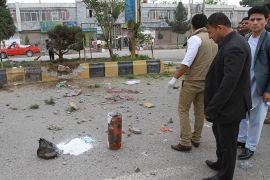 epa03651504 Afghan security officials inspect the site of a bomb blast in Herat, Afghanistan 06 April 2013. Reports state that one policeman was killed in a failed attempt to defuse a bomb planted on a roadside infront of Herat municipality office on 06 April. EPA/JALIL REZAYEE