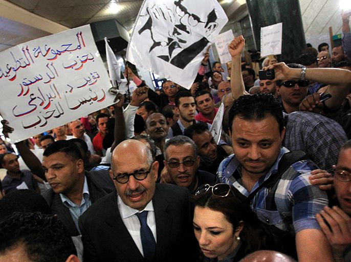 epa03199250 Nobel Peace Prize winner and former head of the International Atomic Energy Agency, Mohamed ElBaradei (2-R) is surrounded by his supporters and media as he arrives to announce the launch of the new 'Adoustour' (the Constitution in Arabic) Party in a press conference at the Egyptian Press Syndicate in Cairo, Egypt, 28 April 2012. Banner at Left reads in Arabic 'the Adoustour Party volunteers want ElBaradei for Party President'. ElBaradei and a group of pro-revolution personalities announced officially on 28 April the launch of the new 'Adoustour' political party aiming at gathering the Egyptian revolutionaries. EPA/AMEL PAIN