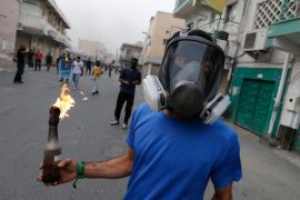 A protester, wearing a gas mask, holds a Molotov cocktail as he waits for riot police during clashes after an anti-government protest in the village of Diraz, west of Manama April 4, 2013. REUTERS/Hamad I Mohammed (BAHRAIN - Tags: POLITICS CIVIL UNREST)