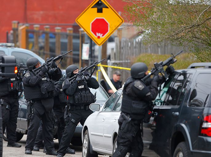 Police officers take position during a search for the Boston Marathon bombing suspects in Watertown, Massachusetts April 19, 2013. Police on Friday killed one suspect in the Boston Marathon bombing during a shootout and mounted a house-to-house search for a second man in the suburb of Watertown after a bloody night of shooting and explosions in the city's streets. REUTERS/Brian Snyder (UNITED STATES - Tags: CRIME LAW)