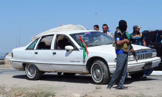 A masked Iraqi gunman stands guard near a civilian vehicle after attacking it in Ramadi, 100 km (62 miles) west of Baghdad April 27, 2013. At least five Iraqi soldiers in civilian clothes were killed and one wounded when gunmen attacked their vehicle Ramadi, Anbar Governorate, early Saturday, police sources said.