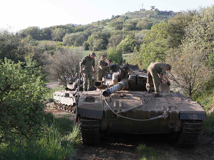 Israeli soldiers stand atop a tank as they clean it close to the ceasefire line between Israel and Syria on the Israeli occupied Golan Heights April 7, 2013. Israel is worried that the Golan, which it captured from Syria in 1967, will become a springboard for attacks on Israelis by jihadi fighters, who are taking part in the armed struggle against Syrian President Bashar al-Assad. Picture taken April 7, 2013. REUTERS/Baz Ratner (MILITARY POLITICS)