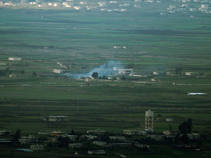 epa03642806 Smoke rises from a Syrian tank located in the demilitarized zoon between Israel and Syria next to the village of Jubata, seen from the Israeli side of the Golan Heights, 27 March 2013. The Israel Defense Forces Chief of Staff allowed local medics to treat seven Syrians rebels wounded who came to the Golan Heights border 27 March, citing humanitarian considerations. EPA/ATEF SAFADI