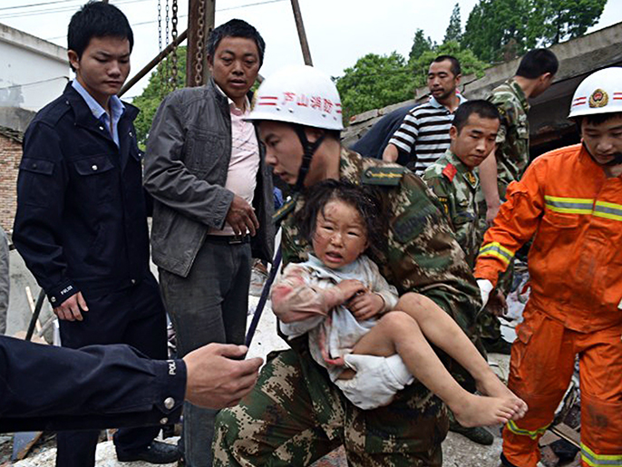 ‪رجل إنقاذ يحمل طفلا انتشله من بين الأنقاض‬ رجل إنقاذ يحمل طفلا انتشله من بين الأنقاض (الفرنسية)