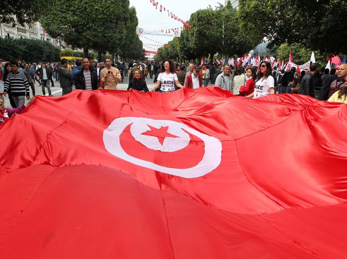 epa03655234 Tunisian women hold the national flag during a march to commemorate the Martyrs Day, in Tunis, Tunisia, 09 April 2013. Martyrs Day is marked annually on 09 April to honor those who defied the French rule. On 09 April 1938, a popular leader of the Neo-Destour (New Constitution) Party was arrested sparking wide-spread protests that were suppressed by French policemen killing at least 22 and injuring some 150 others. EPA/MOHAMED MESSARA