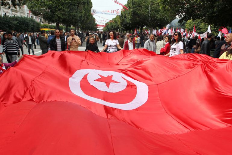 epa03655234 Tunisian women hold the national flag during a march to commemorate the Martyrs Day, in Tunis, Tunisia, 09 April 2013. Martyrs Day is marked annually on 09 April to honor those who defied the French rule. On 09 April 1938, a popular leader of the Neo-Destour (New Constitution) Party was arrested sparking wide-spread protests that were suppressed by French policemen killing at least 22 and injuring some 150 others. EPA/MOHAMED MESSARA