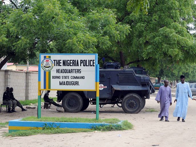 PS001 - Maiduguri, -, NIGERIA : (FILES) People walk past police armoured tank stationed at the main gate of the state police command headquaters in Maiduguri, Borno State Monday on July 26, 2010. Dozens of people have been killed in fierce fighting between Nigeria's military and suspected Islamists after troops raided an insurgent hideout in the northeast, a government source told AFP on April 22, 2013. Gun battles broke out in the remote fishing village of Baga on Friday, forcing residents to flee the town that also serves as a small trading centre on the shores of Lake Chad. The village lies in Borno state, the home base of Boko Haram Islamists who are blamed for carrying out scores of attacks across northern and central Nigeria since 2009. AFP PHOTO / Pius Utomi Ekpei