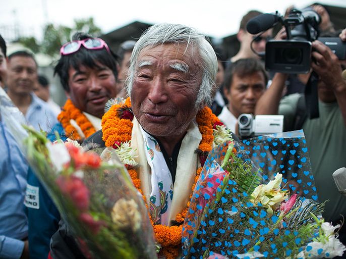 epa03718271 Japanese climber Yuichiro Miura, 80, with his second son Gota (L), waves after they have arrived from Mt. Everest at Kathmandu domestic Airport in Kathmandu , Nepal . 26 May 2013. Japanese professional skier, alpinist, Yuichiro Miura climbed world's highest peak, Mount Everest on 23 May 2013 to become the world's oldest person to reach the summit of Mount Everest. EPA/NARENDRA SHRESTHA