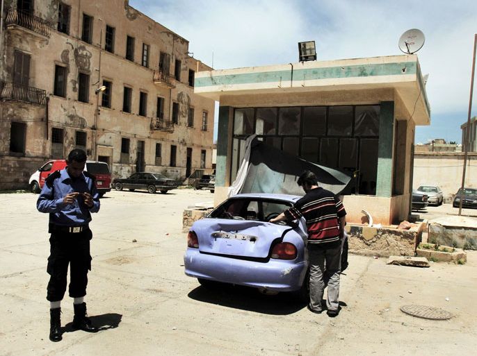 GUE356 - BENGHAZI, -, LIBYA : Members of the Libyan security forces and civilians check one of the two police stations that were attacked on May 10, 2013 in the eastern Libyan city of Benghazi. Bomb attacks targeted two police stations in Benghazi causing extensive material damage but no casualties, a security official said. AFP PHOTO/ABDULLAH DOMA