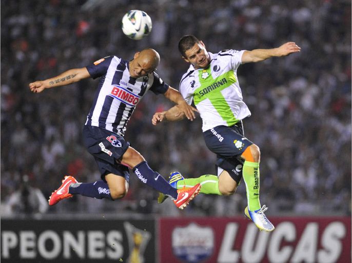 epa03684521 Humerto Suazo (L) of Monterrey vies for the ball against Rafael Figueroa (R) from Santos during their match of the Concacaf held in Monterrey, Mexico, 01 May 2013. EPA/Miguel Sierra