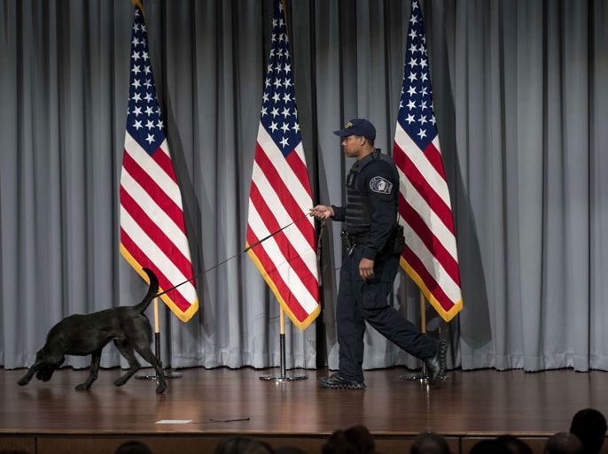 Alexandria, Virginia, UNITED STATES : A Pentagon Police Officer checks a stage with a dog before US Secretary of Defense Chuck Hagel speaks about furloughs during a town hall style meeting at the Department of Defense's MARK Center May 14, 2013 in Alexandria, Virginia. Hagel announced Tuesday that the Department of Defense is reducing to 11 the