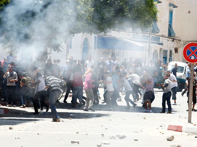 Tear gas is seen as protesters clash with riot police attempting to disperse the crowd in the city of Kairouan May 19, 2013. Supporters of the hardline Islamist group Ansar al-Sharia clashed with Tunisian police on Sunday after the government banned its annual rally, saying it posed a threat to society. REUTERS/Zoubeir Souissi (TUNISIA - Tags: POLITICS CIVIL UNREST)