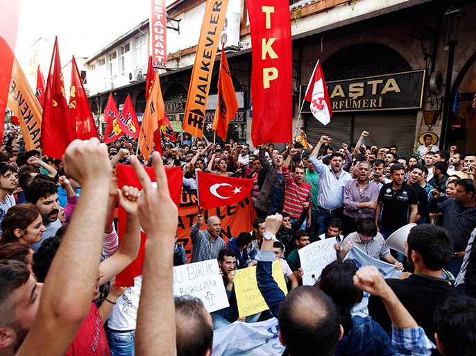 Protesters shout slogans against Turkey's Prime Minister Tayyip Erdogan during a demonstration against the Turkish government's foreign policy on Syria, in central Hatay May 12, 2013. Turkey accused a group loyal to Syrian President Bashar al-Assad on Sunday of carrying out car bombings that killed 46 people in a Turkish border town and said the risk of unrest spreading to Syria's neighbours was increasing. Syrian Information Minister Omran Zubi denied any Syrian involvement and rejected what he called "unfounded accusations". The sign (bottom R) reads, "Condolences to all of us". REUTERS/Umit Bektas (TURKEY - Tags: POLITICS CIVIL UNREST)