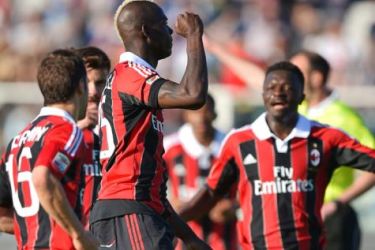 AC Milan striker Mario Balotelli (C) raises his fist as he celebrates with teammates after he scored a goal during the Italian Serie A football match Pescara vs Milan at the Adriaticum stadium in Pescara on May 8, 2013. AFP PHOTO / VINCENZO PINTO