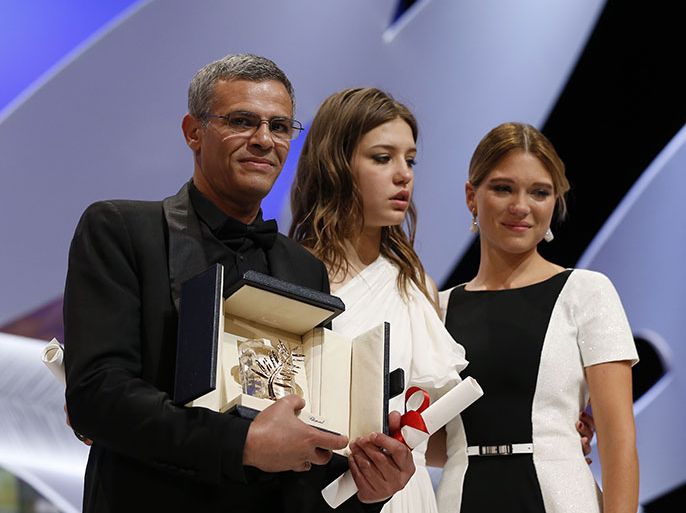 French-Tunisian director Abdellatif Kechiche (L) poses on stage on May 26, 2013 with French actresses Lea Seydoux (R) and Adele Exarchopoulos after he was awarded with the Palme d'Or for the film "Blue is the Warmest Colour" during the closing ceremony of the 66th Cannes film festival in Cannes. AFP PHOTO / VALERY HACHE
