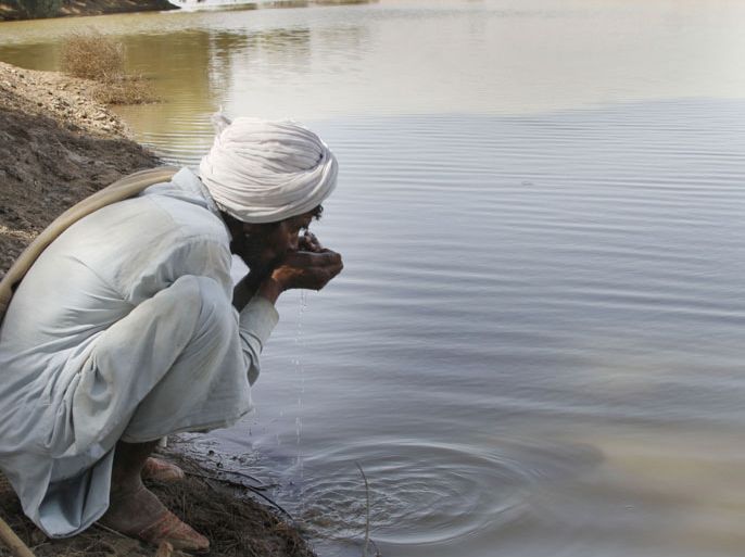 epa03632949 A picture made available on 20 March 2013 shows a man drinking contaminated water from a stream in the Cholistan Desert, near Bahawalpur, Pakistan, 16 March 2013. Drinking water is scarce in desert areas of Pakistan, where the only source of water is rainfall which is bare minimum ranging from 100 to 200 mm and that just for a few months in monsoon. EPA/RAHAT DAR