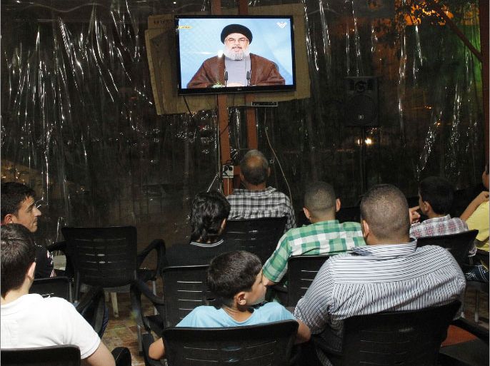 Lebanese men watch Hezbollah leader Hassan Nasrallah delivering a televised speech at a cafe in Beirut on April 30, 2013. The chief of powerful Lebanese Shiite Muslim party Hezbollah, a close Damascus ally, said that Syria's friends would not let the embattled regime of President Bashar al-Assad fall. AFP PHOTO / ANWAR AMRO