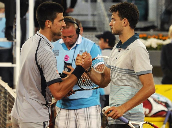 Serbian player Novak Djokovic (L) shakes hands with Bulgarian player Grigor Dimitrov at the end of their tennis match at the Madrid Masters at the Magic Box (Caja Magica) sports complex in Madrid on May 7, 2013. Dimitrov won the match 7-6, 6-7, 6-3. AFP PHOTO / DOMINIQUE FAGET