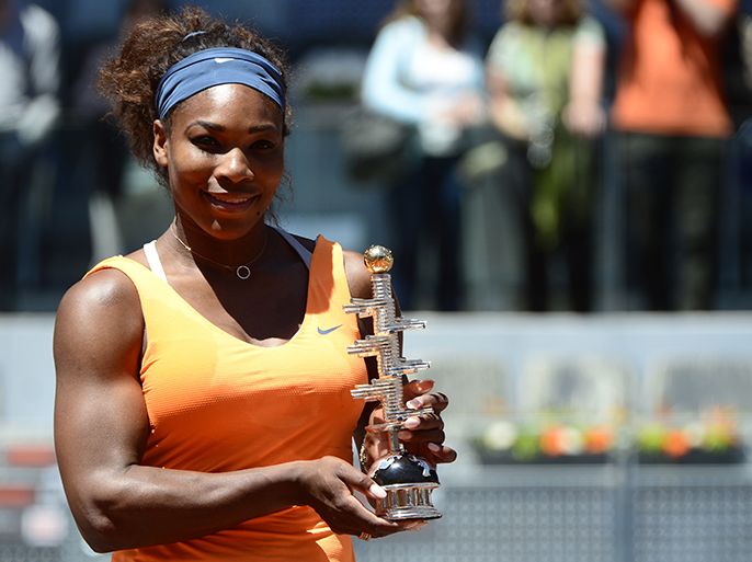 US player Serena Williams holds the trophy after winning the women's singles final tennis match of the Madrid Masters against Russian player Maria Sharapova at the Magic Box (Caja Magica) sports complex in Madrid on May 12, 2013. Williams won the match 6-1, 6-4. AFP PHOTO / JAVIER SORIANO