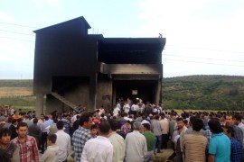People gather in front of an illegal fuel depot on May 17, 2013, after suspects set ablaze the depot located in the basement of a three-storey building in a small village near Turkey's border with Syria, triggering a strong explosion that killed at least ten people and wounded nine others. Among the wounded were three suspected smugglers as well as several security officers, Anatolia news agency reported. AFP