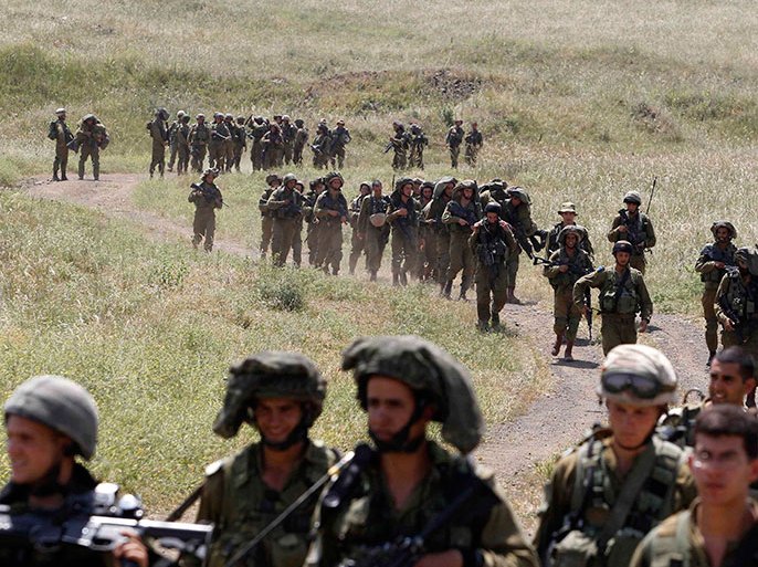Israeli soldiers walk together during a training close to the ceasefire line between Israel and Syria on the Israeli occupied Golan Heights May 7, 2013. Israel played down weekend air strikes close to Damascus reported to have killed dozens of Syrian soldiers, saying they were not aimed at influencing its neighbour's civil war but only at stopping Iranian missiles reaching Lebanese Hezbollah militants. REUTERS/Baz Ratner (MILITARY POLITICS)