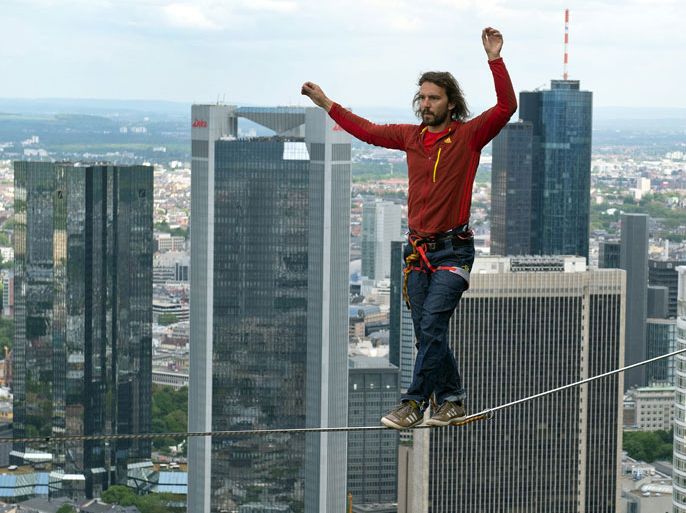 The professional slackliner Reinhard Kleindl from Austria walks on a 185 m high rope between two towers of the 'Tower 185' during the skyscraper festival in Frankfurt/Main, Germany, 25 May 2013. Several hundred thousand visitors are expected to come to the two-day spectacle. Highlights are spectacular performances in the air and numerous concerts. EPA