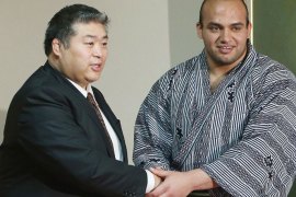Twenty-one-year-old Egyptian sumo wrestler Abdelrahman Ahmed Shaalan (R), who goes by the ring name of "Osunaarashi", is congratulated by his stablemaster Tadahiro Otake (L) after being promoted to the second highest division in the sport, at a press conference in Tokyo on May 29, 2013. Osunaarashi, the first professional sumo wrestler from either Africa or the Arab world, won promotion to the "jyuryo" division after finishing the latest tournament in Tokyo this month with a 7-0 record. JAPAN OUT AFP PHOTO / JIJI PRESS