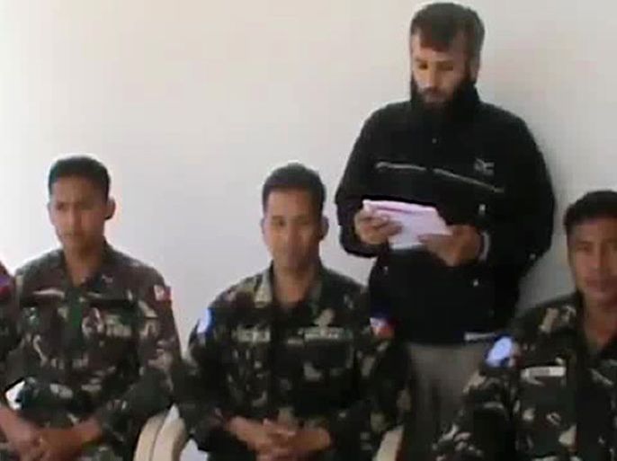 An image grab taken from a video uploaded on YouTube on May 08, 2013 reportedly shows a man reading a statement at an undisclosed location in Syria, behind four abducted Filipino UN peacekeepers. A Syrian rebel group which calls itself the "Yarmuk Martyrs Brigade" seized the four Filipino peacekeepers at an observation post in the Golan Heights on May 7, two months after 21 Filipino soldiers were abducted by the same group and held for four days. The Philippines said it may quickly withdraw from a United Nations peacekeeping force in the Golan Heights because of security concerns. == RESTRICTED TO EDITORIAL USE - MANDATORY CREDIT "AFP PHOTO/HO/YOUTUBE" - NO MARKETING NO ADVERTISING CAMPAIGNS - DISTRIBUTED AS A SERVICE TO CLIENTS - AFP IS USING PICTURES FROM ALTERNATIVE SOURCES, THEREFORE IT IS NOT RESPONSIBLE FOR ANY DIGITAL ALTERATIONS TO THE PICTURE'S EDITORIAL CONTENT, DATE AND LOCATION WHICH CANNOT BE INDEPENDENTLY VERIFIED ==