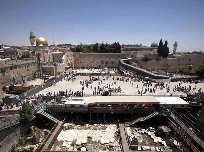 Labourers use a hydraulic drill as they work on foundations of a new complex (L) that will include a synagogue, a reception hall and a police station in the Western Wall plaza (facing) of Jerusalem's Old City with the Dome of the Rock mosque and Al Aqsa mosque compound in the background seen on May 20, 2013. Israel said it called off a United Nations investigative mission to Jerusalem's Old City due to start because of Palestinian efforts to politicise the visit, as the UN said it was postponed. AFP Photo/AHMAD GHARABLI