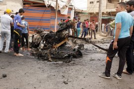 Baghdad, -, IRAQ : Iraqis look at the remains of a car bomb that detonated in the Kamaliya area of eastern Baghdad on May 20, 2013. A wave of 12 bomb attacks across Iraq killed at least 15 people and wounded dozens more, security and medical officials said.