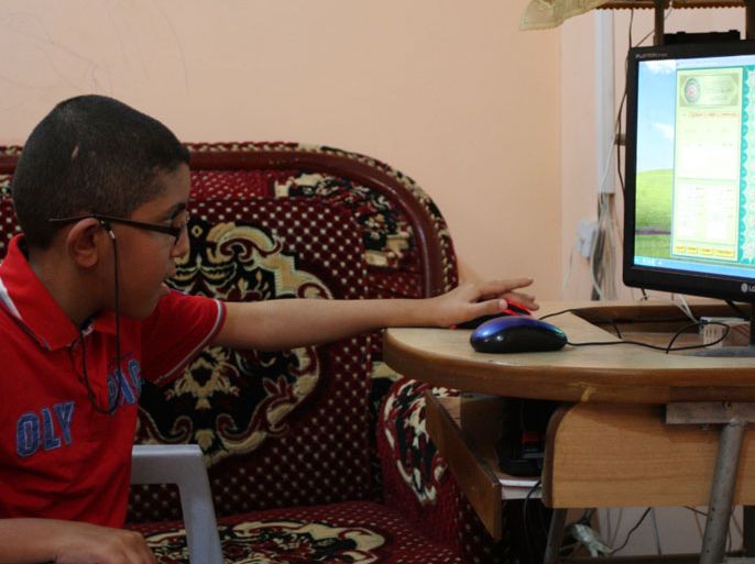 خالد يستمع إلى القرآن الكريم عبر جهاز الكمبيوتر في منزله