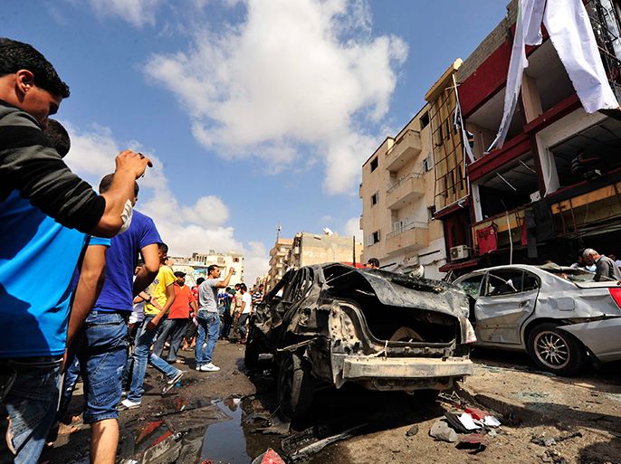 Onlookers take photographs following a car bomb explosion outside a hospital in Benghazi May 13, 2013. At least three people were killed and 17 wounded on Monday when the bomb exploded, a doctor at the hospital said. A second doctor said only one of the bodies had arrived intact, making it difficult to immediately establish the number killed. REUTERS/Esam Al-Fetori (LIBYA - Tags: CIVIL UNREST TPX IMAGES OF THE DAY)