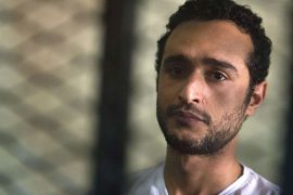 Egyptian political activist Ahmed Douma stands behind dock bars during his trial in Cairo on May 13, 2013 on charges of insulting president Mohamed Morsi in a TV interview. AFP PHOTO / KHALED DESOUKI
