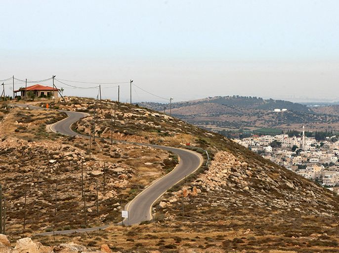 A picture taken on May 17, 2013 shows a house in the Mitzpe Lachish Israeli settlement outpost (L) in front of the West Bank village of Beit Awwa (R). Israeli settlement watchdog Peace Now said on May 16, 2013 that the government wants to give retroactive approval to four West Bank settlement outposts it had previously pledged to at least partially demolish. Givat Assaf, Givat HaRoeh, Maaleh Rehavam and Mitzpe Lachish outposts are among six listed in a 2005 government report as deserving immediate eviction and later ordered shut by a court order. AFP PHOTO / HAZEM BADER