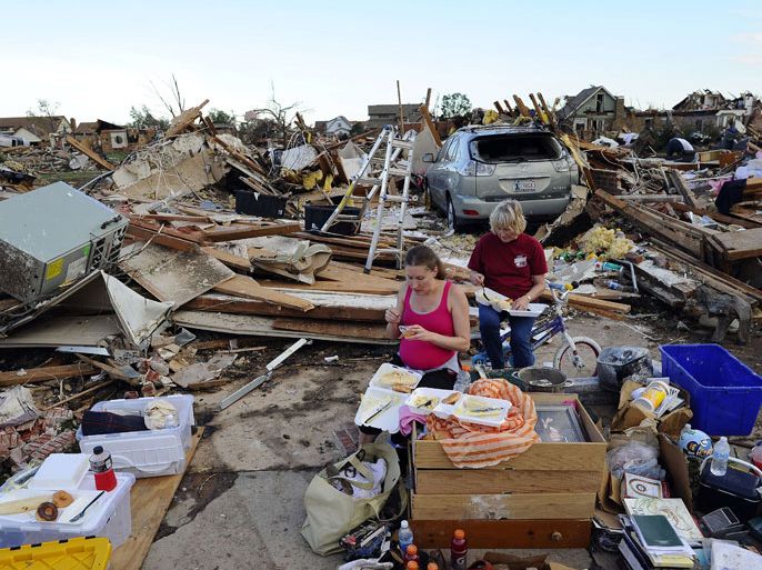 People go through the debris of their tornado-devastated homes looking for salvageable stuffs on May 22, 2013 in Moore, Oklahoma. As rescue efforts in Oklahoma wound down, residents turned to the daunting task of rebuilding a US heartland community shattered by a vast tornado that killed at least 24 people. The epic twister, two miles (three kilometers) across, flattened block after block of homes as it struck mid-afternoon on May 20, hurling cars through the air, downing power lines and setting off localized fires in a 45-minute rampage