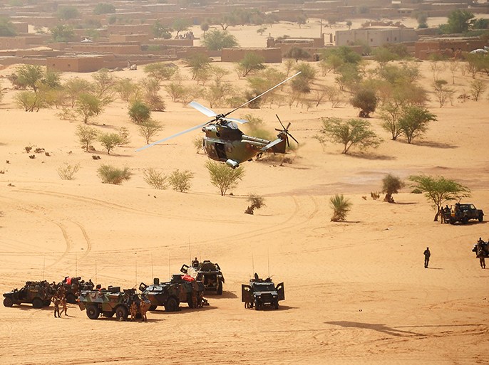 (FILES) A picture taken on February 17, 2013, near Bourem, northern Mali, shows a Puma helicopter fyings above French military vehicles during a French-led military intervention launched against Islamist rebels in Mali. Some 24,000 jobs will be cut in the French army within 2019, according to Defense Minister Jean-Yves Le Drian's report, handed over to French president on April 29, 2013. 54,000 jobs have been already cut in 2009 during Nicolas Sarkozy's presidency. AFP PHOTO PASCAL GUYOT