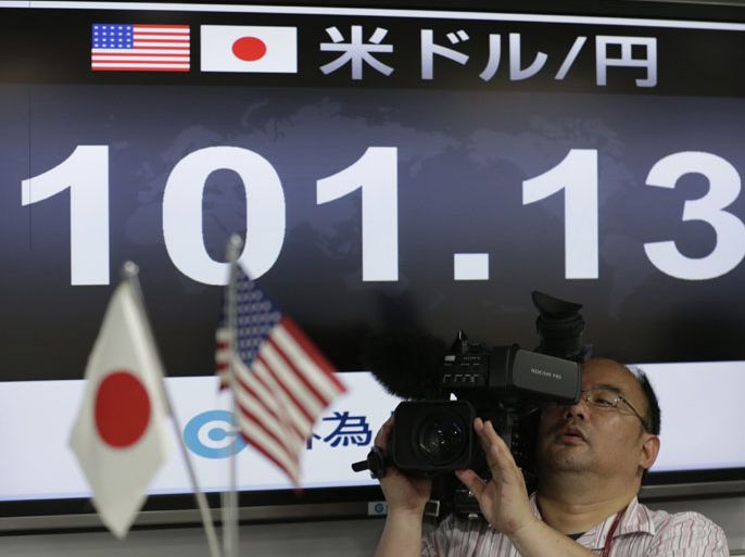 A TV cameraman films in front of a monitor displaying the Japanese yen's exchange rate against the U.S. dollar at a foreign exchange company in Tokyo May 10, 2013. The dollar remained at a lofty perch against its Japanese counterpart on Friday, after breaking above the 100 yen level in the previous session for the first time since April 2009. REUTERS/Toru Hanai (JAPAN - Tags: BUSINESS MEDIA