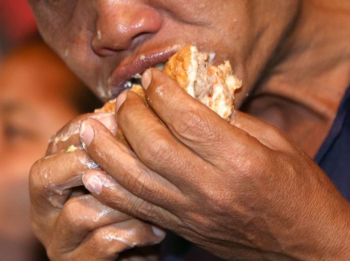 epa01990756 Participant Pairat Pattanapiboon, aged 51, eats a whopper burger during a Whopper Eating Contest in Bangkok, Thailand, 16 January 2010. Pairat, the winner of the contest, eat five chunk of whopper burgers in twelve minutes. The event was held to promote the animated movie 'Cloudy with a Chance of Meatballs' in Thailand. EPA/NARONG SANGNAK