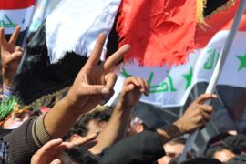 متظاهرون في ساحة اعتصام الانبار يحملون الاعلام العراقية ويرفعون شارة النصر