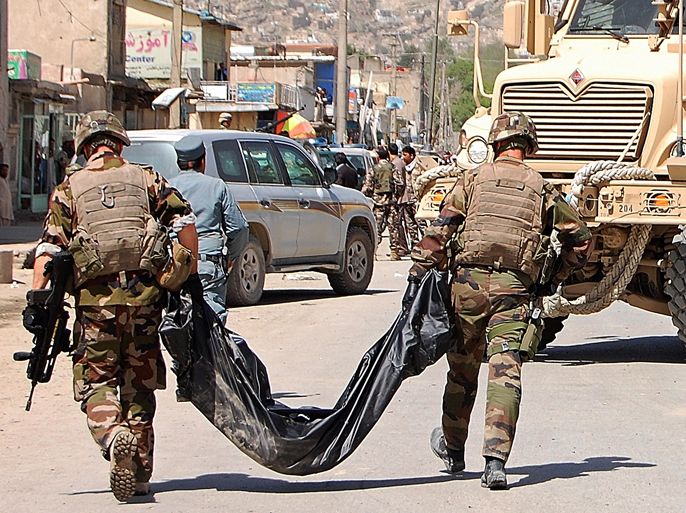 Kabul, -, AFGHANISTAN : French soldiers with the NATO-led International Security Assistance Force (ISAF) carry away the body of a victim from the site of a suicide attack in Kabul on May 16, 2013. A powerful suicide car bomb targeting a NATO military convoy in Kabul has killed eight Afghan civilians including two children in the first major attack in the capital for more than two months. Government officials said eight passers-by died in the explosion in the Shah Shaheed residential district in southeast Kabul, while the NATO coalition was unable to give details of any casualties