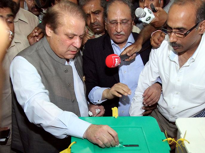 Former Pakistani prime minister Nawaz Sharif (L), casts his vote at a polling station in Lahore on May 11, 2013. Sharif, the frontrunner in Pakistan's landmark election, cast his ballot on May 11 and said he was confident of victory. The vote marks the first time that an elected civilian administration has completed a full term and handed power to another through the ballot box in a country where there have been three military coups and four military rulers. AFP PHOTO / ARIF ALI