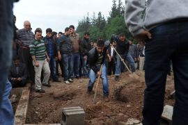 Reyhanli, Hatay, TURKEY : Men shovel dirt at the cemetery of Reyhanli on May 12, 2013 during the funerals of the of victims of a car bomb which went off on May 11 at Reyhanli in Hatay just a few kilometres from the main border crossing into Syria. Turkey was reeling from twin car bomb attacks which left at least 43 people dead in a town near the Syrian border, with Ankara blaming pro-Damascus groups and vowing to bring the perpetrators to justice. A Syrian minister denied on May 12 accusations that Damascus was behind a bomb attack in a Turkish town that left dozens dead, a day after Ankara blamed supporters of President Bashar al-Assad for the blasts. AFP PHOTO / BULENT KILIC