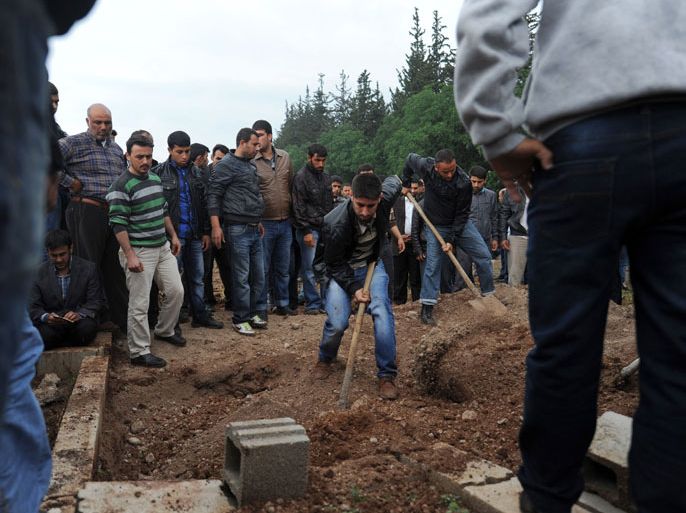 Reyhanli, Hatay, TURKEY : Men shovel dirt at the cemetery of Reyhanli on May 12, 2013 during the funerals of the of victims of a car bomb which went off on May 11 at Reyhanli in Hatay just a few kilometres from the main border crossing into Syria. Turkey was reeling from twin car bomb attacks which left at least 43 people dead in a town near the Syrian border, with Ankara blaming pro-Damascus groups and vowing to bring the perpetrators to justice. A Syrian minister denied on May 12 accusations that Damascus was behind a bomb attack in a Turkish town that left dozens dead, a day after Ankara blamed supporters of President Bashar al-Assad for the blasts. AFP PHOTO / BULENT KILIC