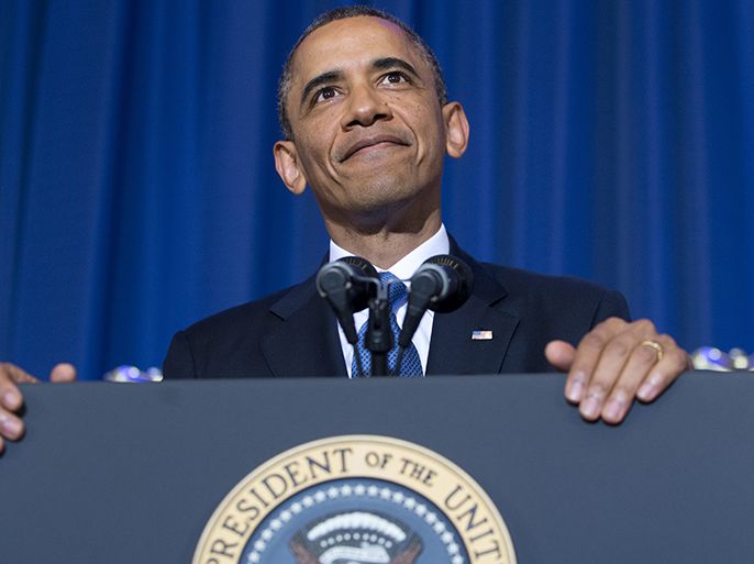US President Barack Obama listens as a protester shouts during a speech about his administration's drone and counterterrorism policies, as well as the military prison at Guantanamo Bay, at the National Defense University in Washington, DC, May 23, 2013