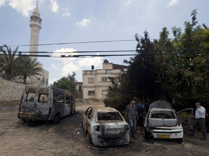 Arab-Israelis inspect burnt vehicles that were set on fire by unknown vandals in the northern Arab-Israeli town of Umm al-Qutuf, south of Haifa, on May 14, 2013. Graffiti attributed to Jewish right-wing extremists reading: "The price to pay" was also found on the wall of a mosque in the village. AFP