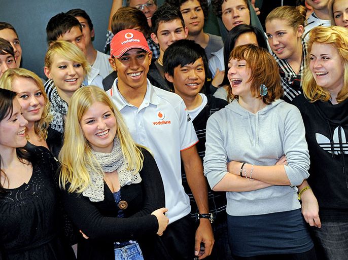 epa02362013 Pupils of John Lennon school direct questions at British Formula One driver Lewis Hamilton (C) of McLaren Mercedes in Berlin, Germany, 28 September 2010. Hamilton talked about his career and his motivation. EPA/BRITTA PEDERSEN